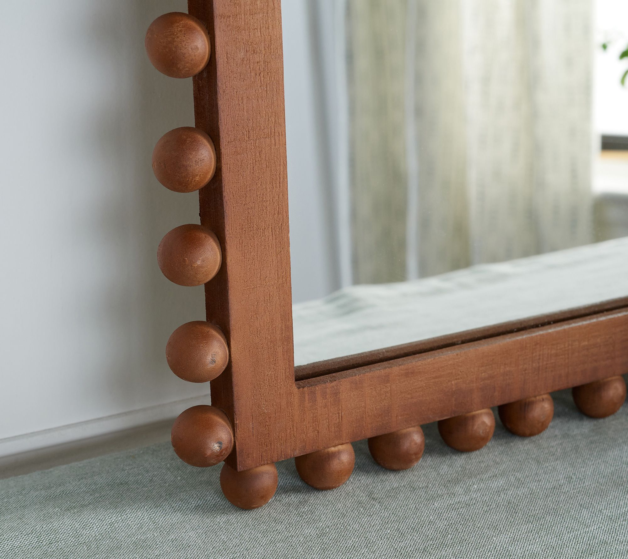 Cylindrical wood beads hand-sewn in a unique design over a metal frame.  Mirror comes with metal